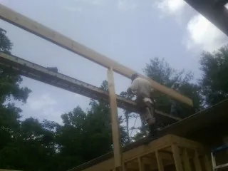 Carpenter setting a ridge beam over a new addition frame — Ice Dam Removal by Roofing Brothers in Richmond Hill